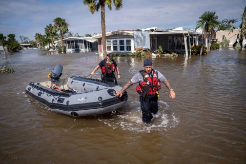 Search and rescue personnel wade through the waters of a flooded neighborhood in Fort Myers, Florida, on Thursday.