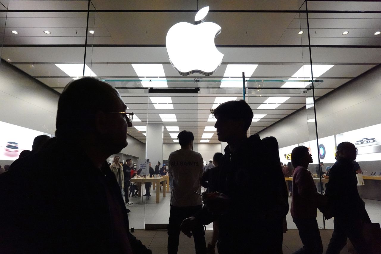 People walk past an Apple store in the Americana at Brand shopping center on December 26, 2023 in Glendale, California.?