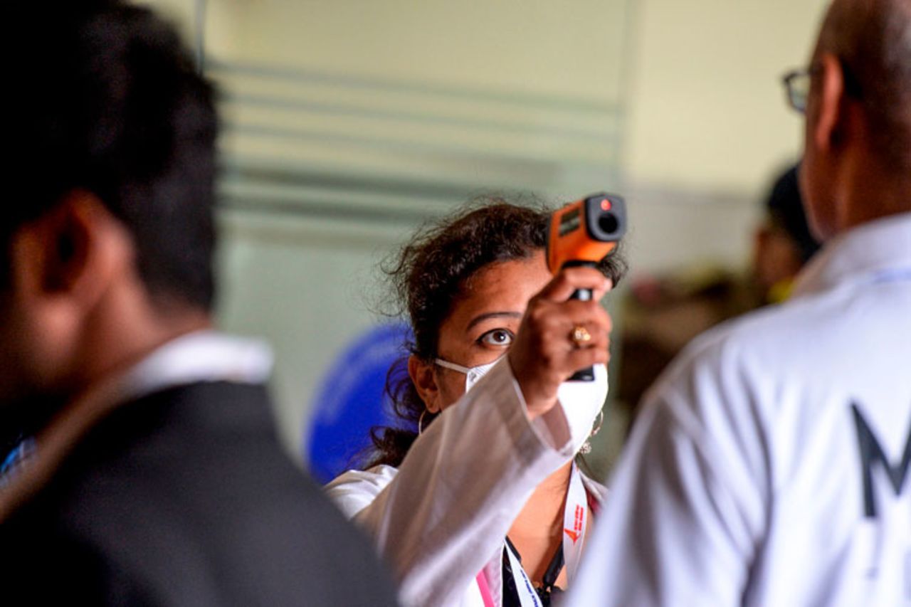 A health worker checks the temperature of visitors and exhibitors amid concerns of the spread of the coronavirus at the entrance of the Wings India 2020 international exhibition at Begumpet Airport in Hyderabad on March 14.