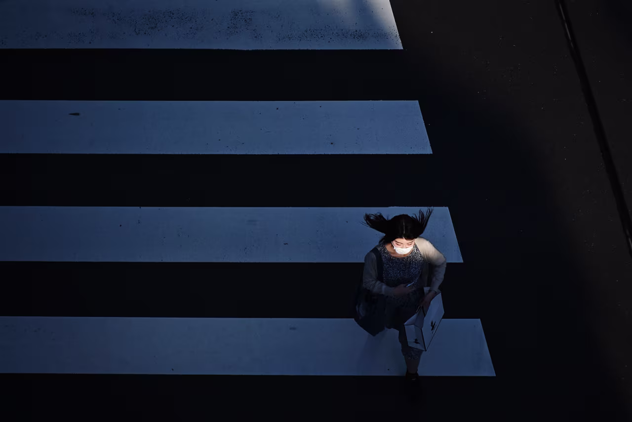 A woman crosses a street in Tokyo's Shinbashi area on May 29.