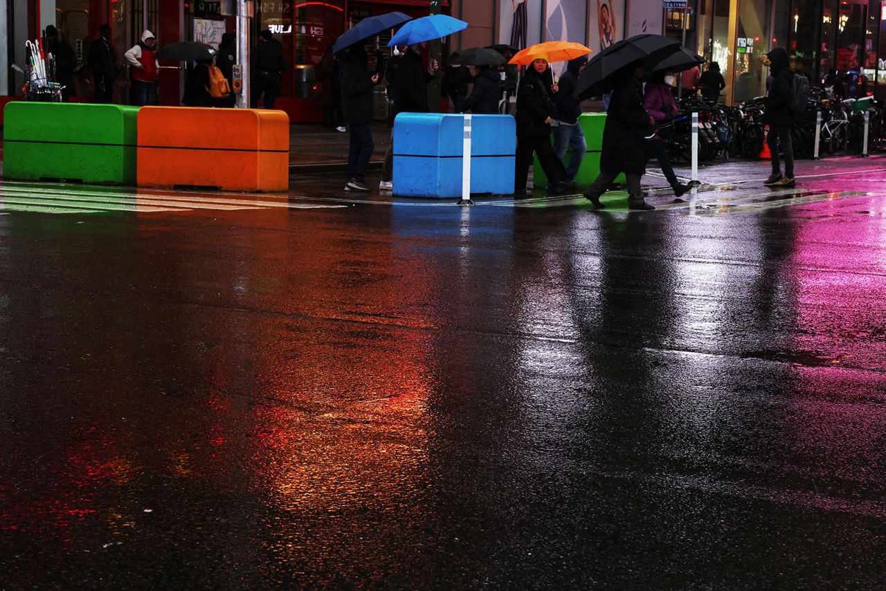 People walk with umbrellas in New York on Tuesday.