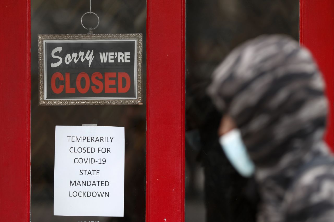 A pedestrian walks by The Framing Gallery, closed due to the Covid-19 pandemic, in Grosse Pointe, Michigan, on May 7.