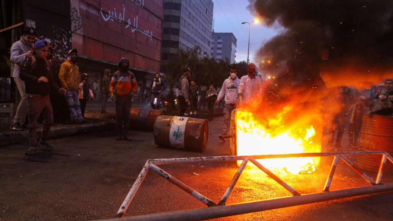 Demonstrators set a garbage bin on fire and block a road during a protest in Tripoli, Lebanon, on Tuesday.