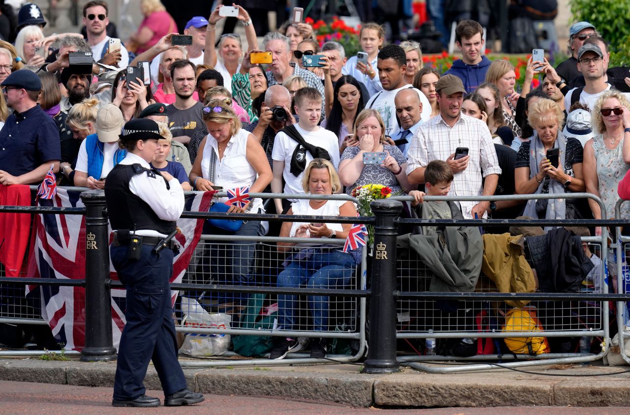 Members of the public wait along The Mall prior to the procession from Buckingham Palace to Westminster Hall in London on Wednesday.