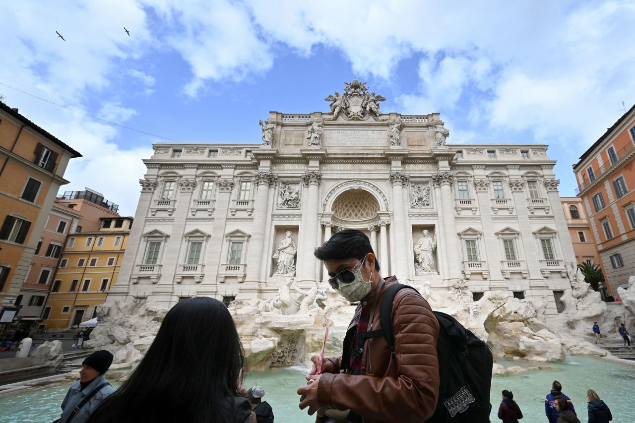 Tourists wear protective masks in front of the Trevi fountain in Rome, Italy on March 3. 