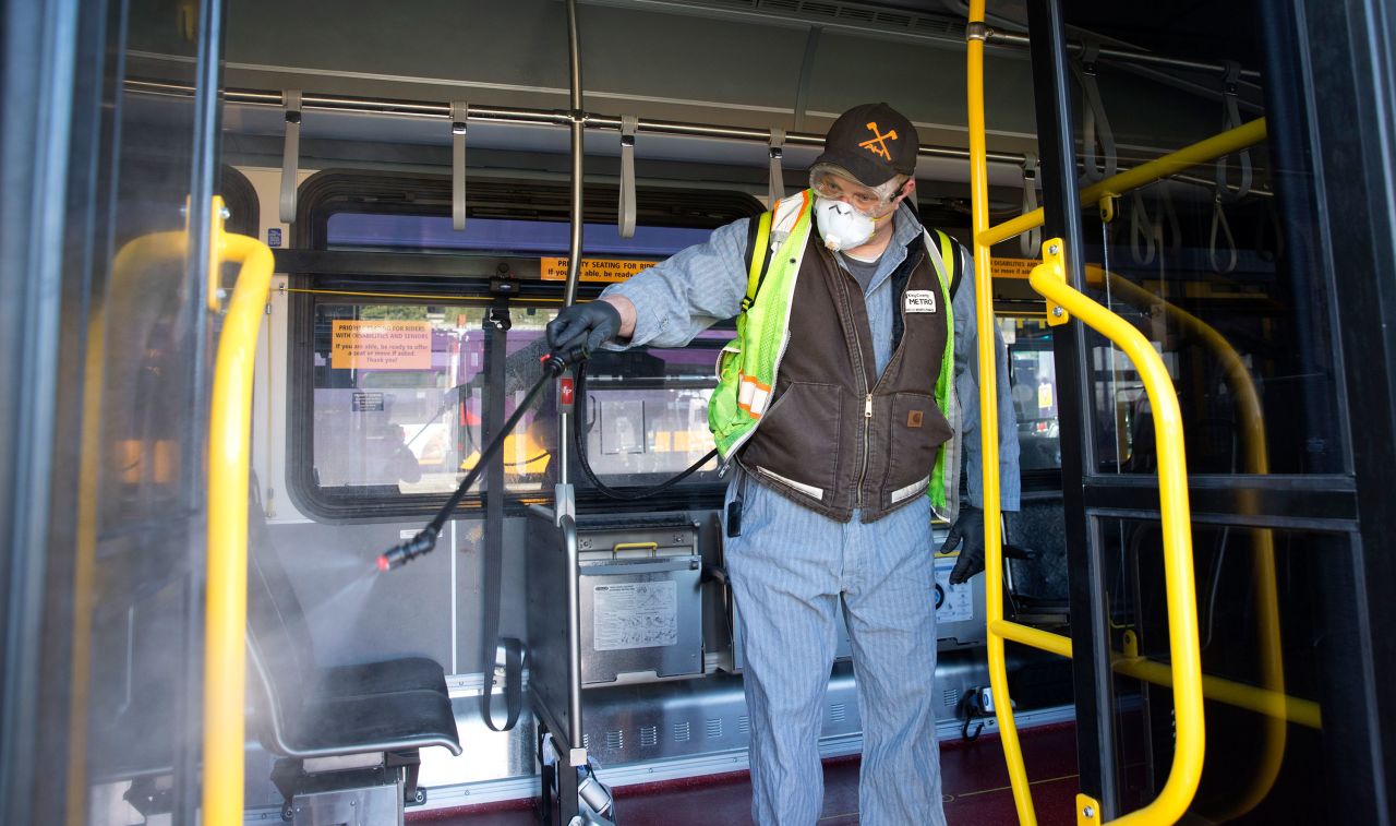 An equipment service worker for King County Metro sprays disinfectant throughout a metro bus in Seattle on March 4.