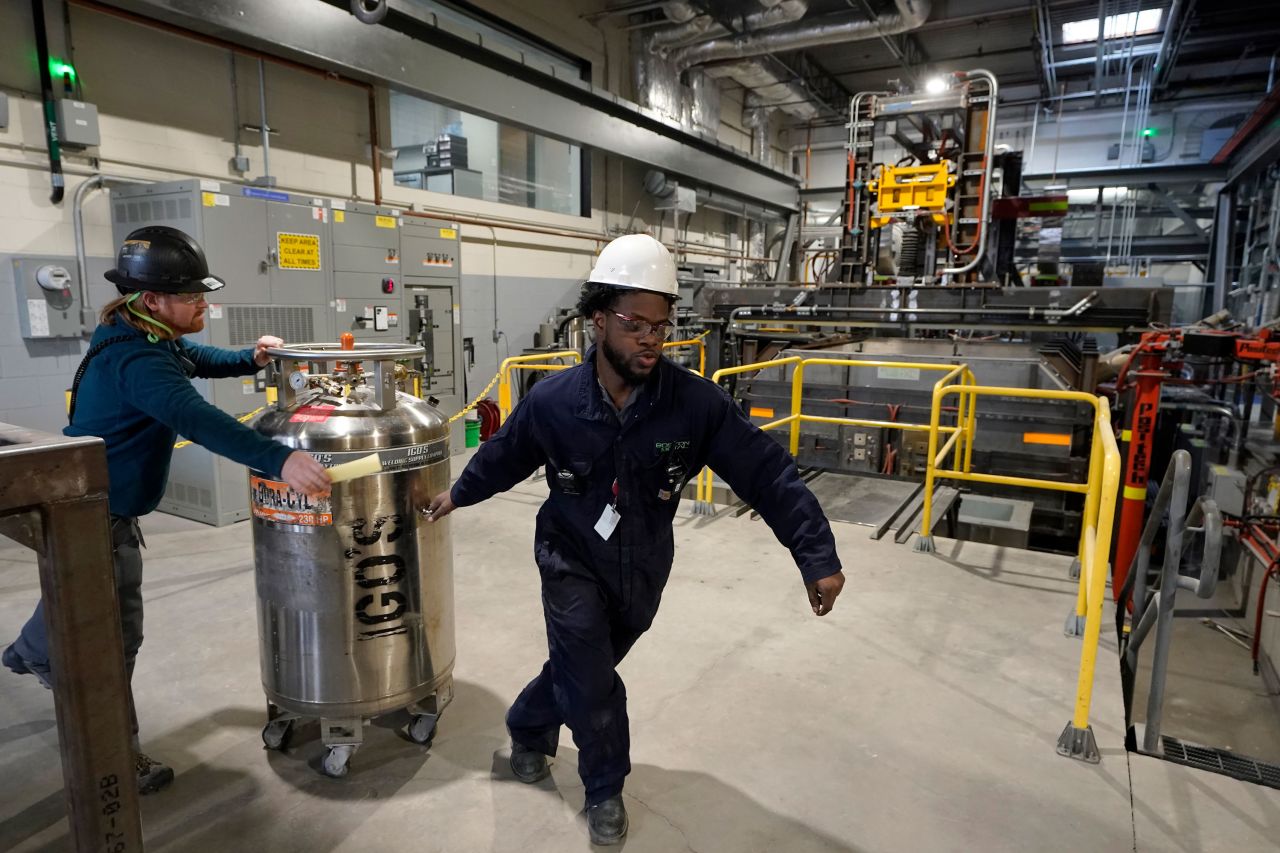 Workers transport equipment at Boston Metal on January 25, 2023, in Woburn, Massachusetts.