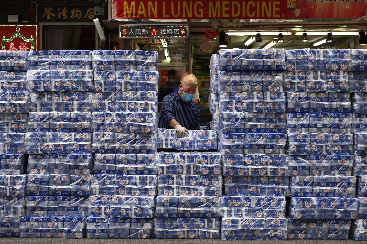 A man wearing a facemask moves packages of toilet paper that are sold at a store in Tsuen Wan district of Hong Kong on Saturday.