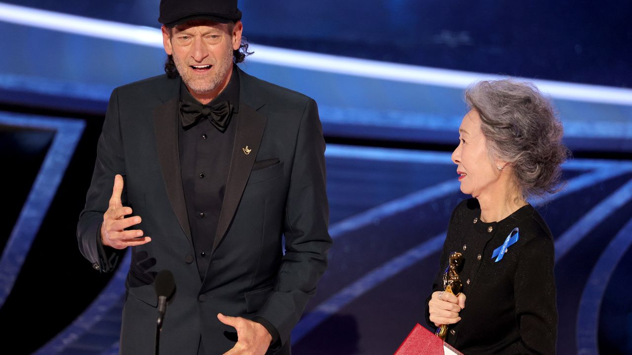 Troy Kotsur, left, accepts the actor in a supporting role award for “CODA” from Youn Yuh-jung onstage during the 94th Annual Academy Awards.