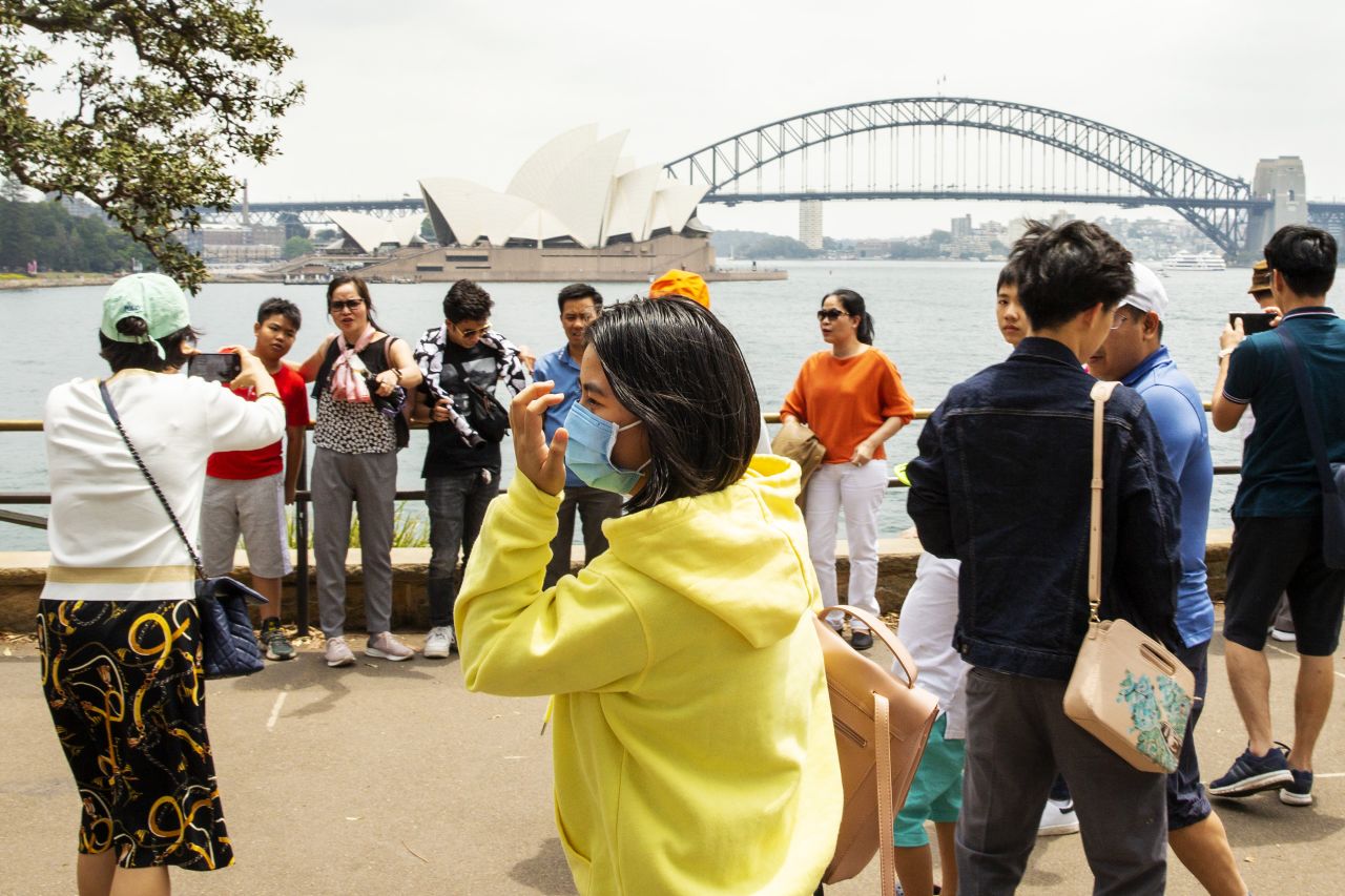 Tourists wear protective masks in Sydney. 