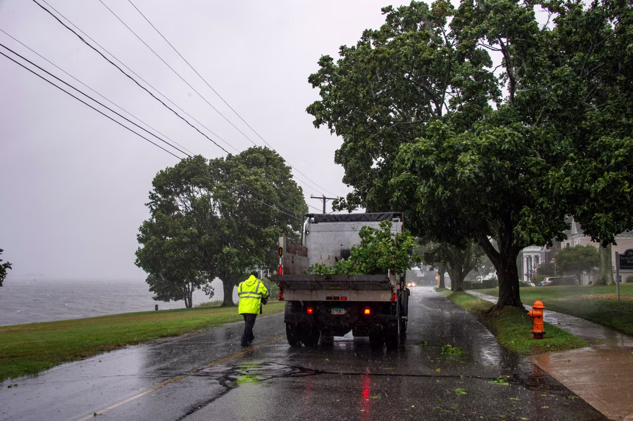 A city worker collects fallen branches in New London, Connecticut, on August 22, 2021.