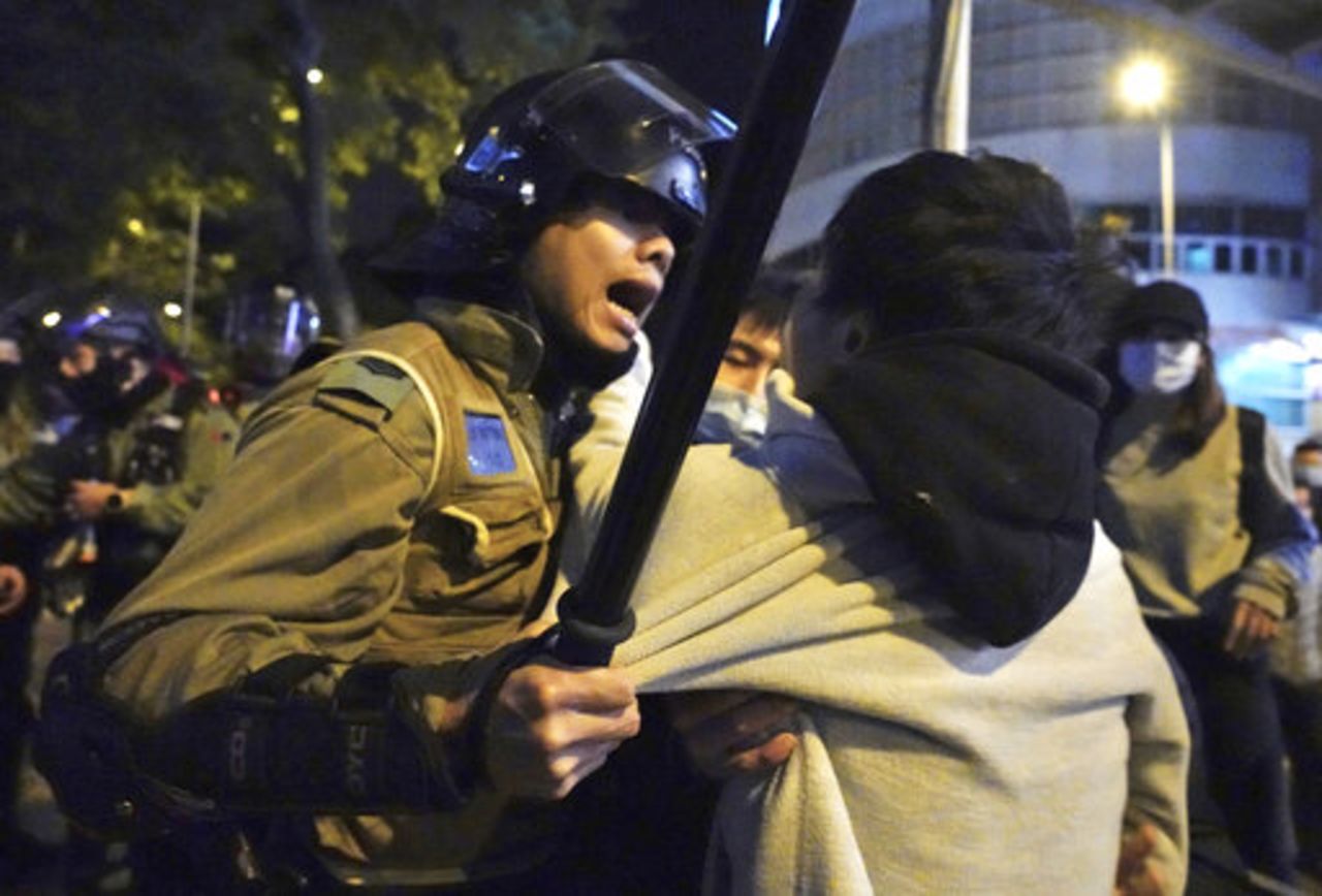 A local resident struggles with riot police in Hong Kong on Sunday.