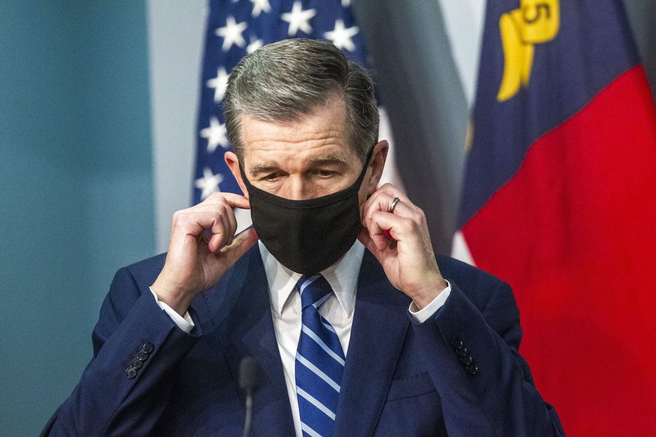 Gov. Roy Cooper removes his mask before speaking at a briefing on the state's coronavirus pandemic response at the N.C. Emergency Operations Center in Raleigh, North Carolian, on December 8. 