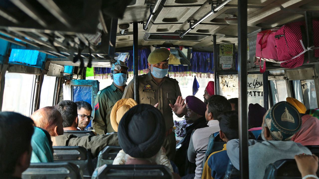 A Jammu and Kashmir police officer briefs bus passengers about the coronavirus in Lakhanpur, India on March 4.