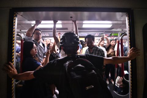 A protester blocks a subway train at Fortress Hill station on August 5.