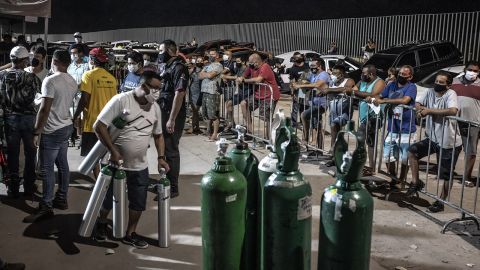 People wearing protective masks wait in line to refill oxygen tanks in Manaus, Brazil, on Sunday, January 17.