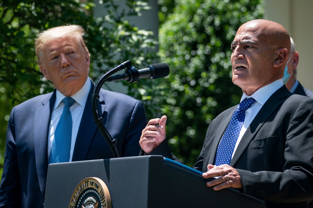 President Donald Trump listens as Moncef Slaoui, the head of the US government's effort to develop a?vaccine against Covid-19, speaks about coronavirus vaccine development in the Rose Garden of the White House, in Washington, DC on May 15.