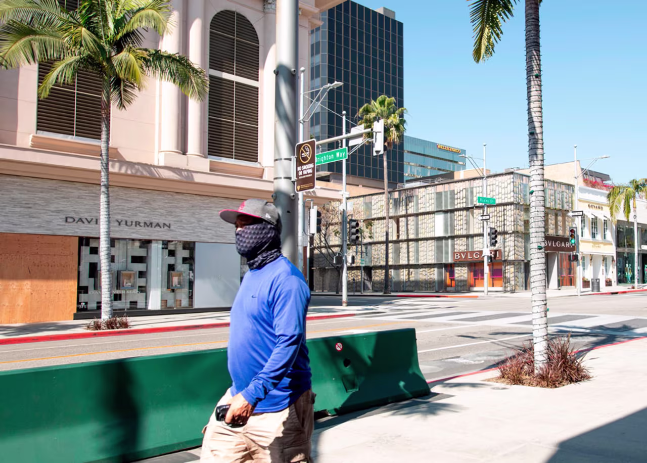 A person wearing a mask walks on Rodeo Drive in Beverly Hills, California on April 1.