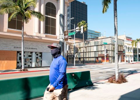 A person wearing a mask walks on Rodeo Drive in Beverly Hills, California on April 1.