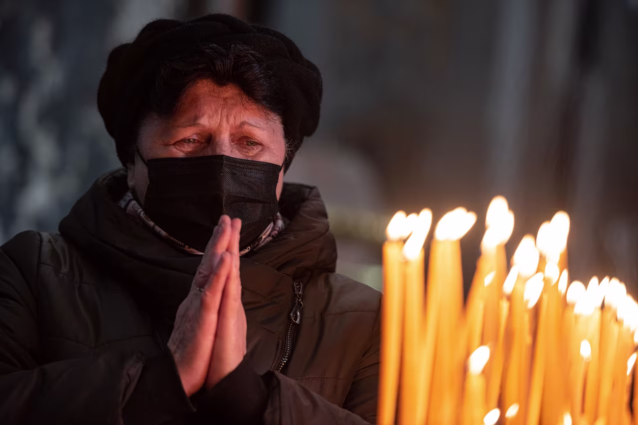 A woman prays during a church service at Saints Peter and Paul Garrison Church in Lviv on Sunday.