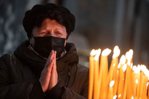 A woman prays during a church service at Saints Peter and Paul Garrison Church in Lviv on Sunday.