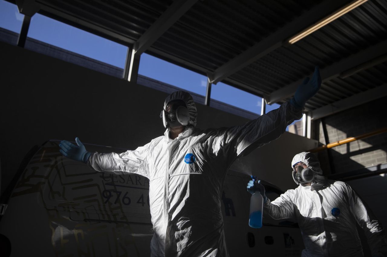 Cemetery workers disinfect each other after moving the body of a coronavirus victim at the Torrero de Zaragoza crematorium on April 13, in Zaragoza, Spain.