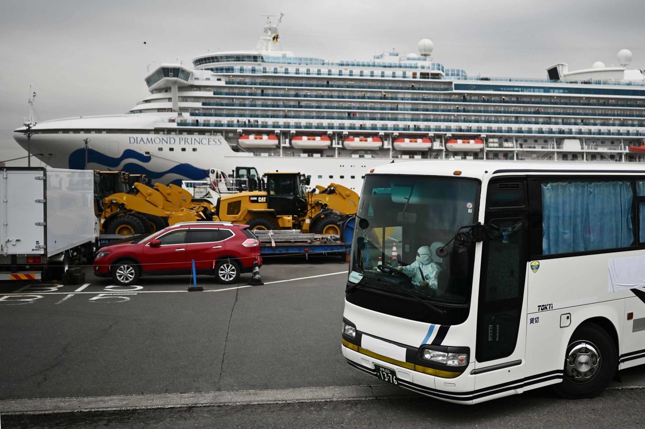 A bus with a driver wearing full protective gear departs from the port where the Diamond Princess cruise shipis docked in Yokohama, Japan, on Friday. 