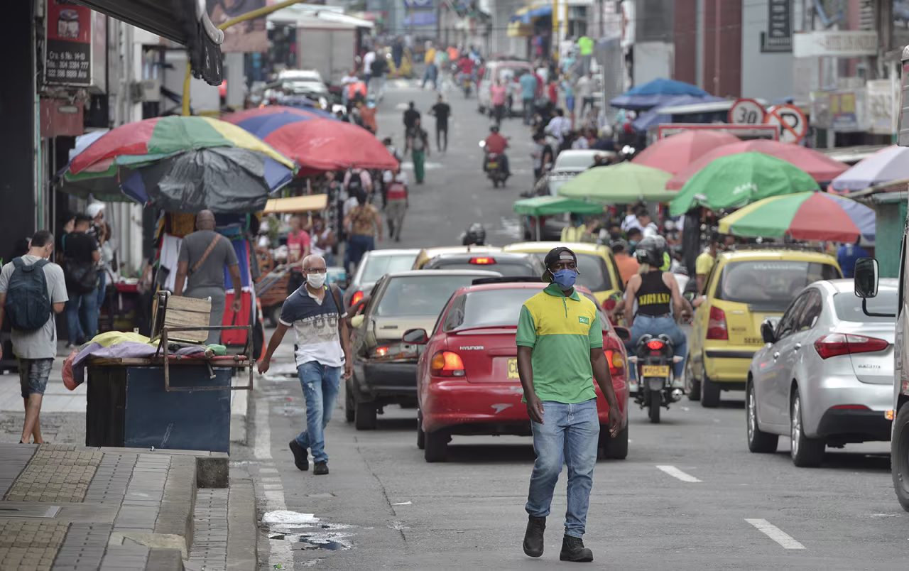 A man wearing a face mask walks down a busy street in Cali, Colombia, on June 1.
