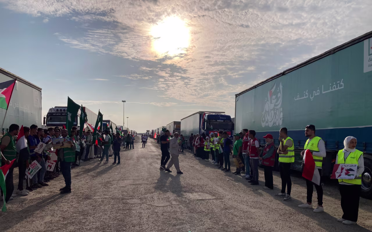 Volunteers stand in front of trucks carrying humanitarian aid at the Rafah border crossing, on October 31.