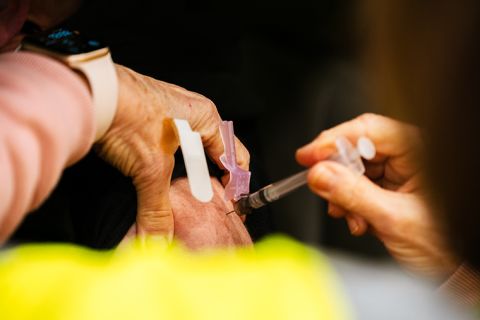 A health worker administers a vaccine to a patient in their vehicle during the first day of mass Moderna COVID-19 vaccinations at the Kentucky State Fair and Exposition Center on Monday, January 4, in Louisville, Kentucky. 
