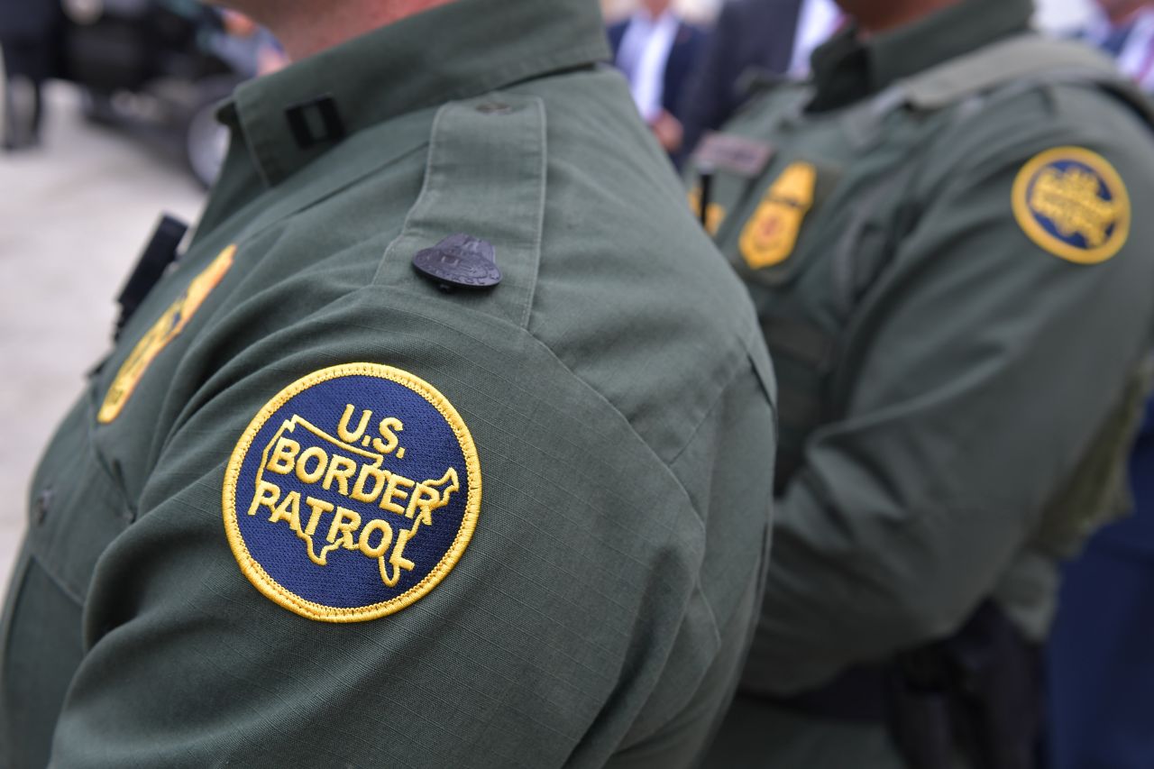 Members of the US Border Patrol listen as US President Donald Trump speaks after inspecting border wall prototypes in San Diego, California on March 13, 2018.