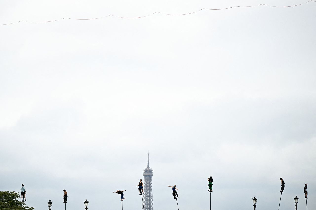 Dancers attend a rehearsal on the Pont Neuf before the opening ceremony of the Paris 2024 Olympic Games in Paris on July 26, 2024, with the top of the Eiffel tower in the background. 