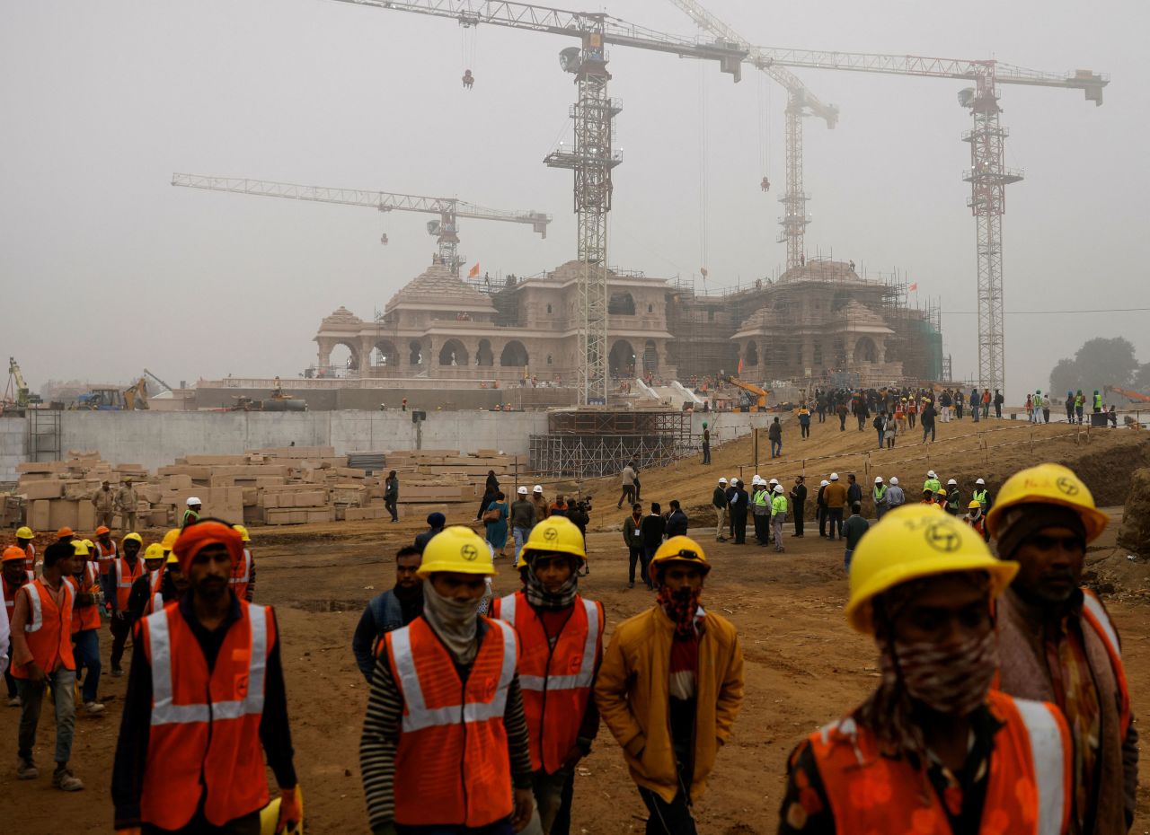 Workers walk in front of the site of the Ram Janmabhoomi Mandir in Ayodhya, India, while it is under construction on December 29, 2023. 