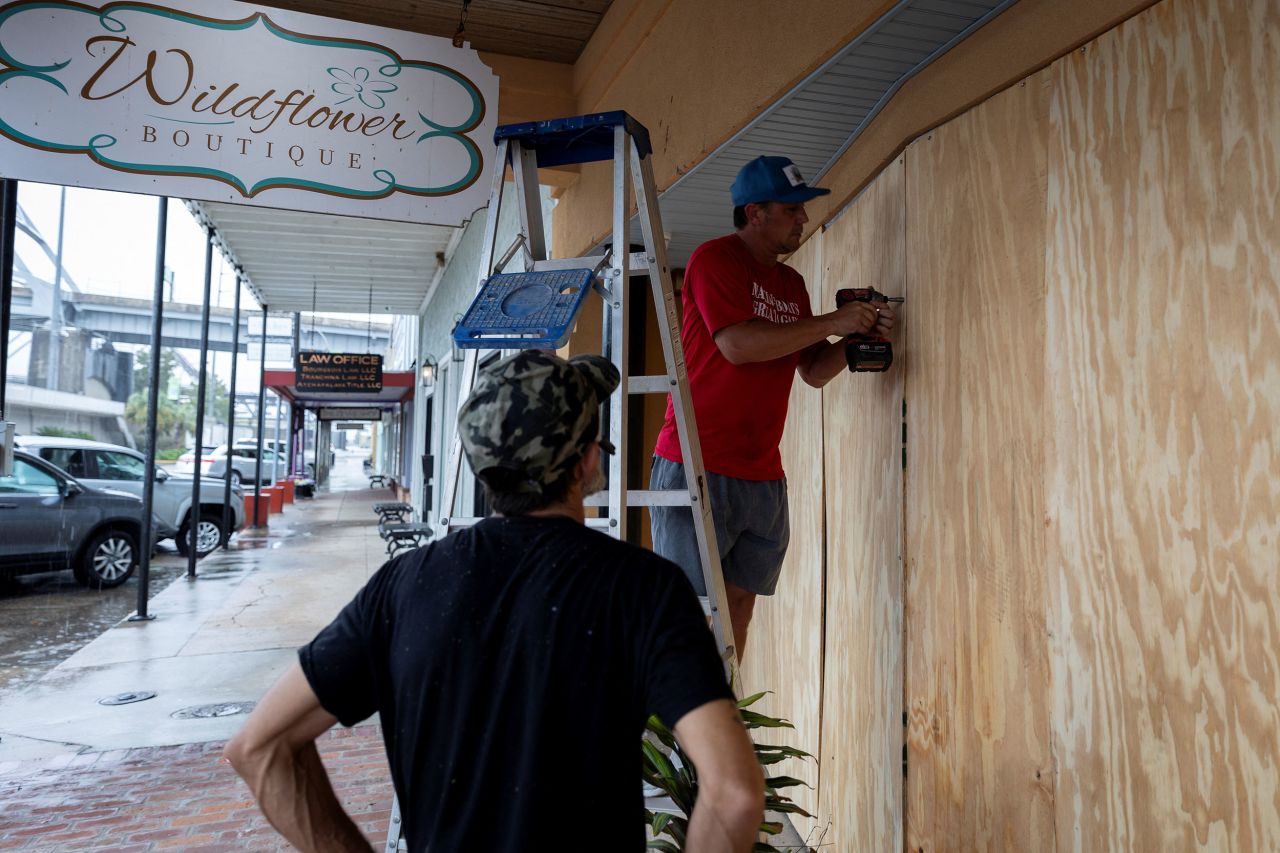 Men board up a window as Francine intensifies in Morgan City, Louisiana, on September 10.