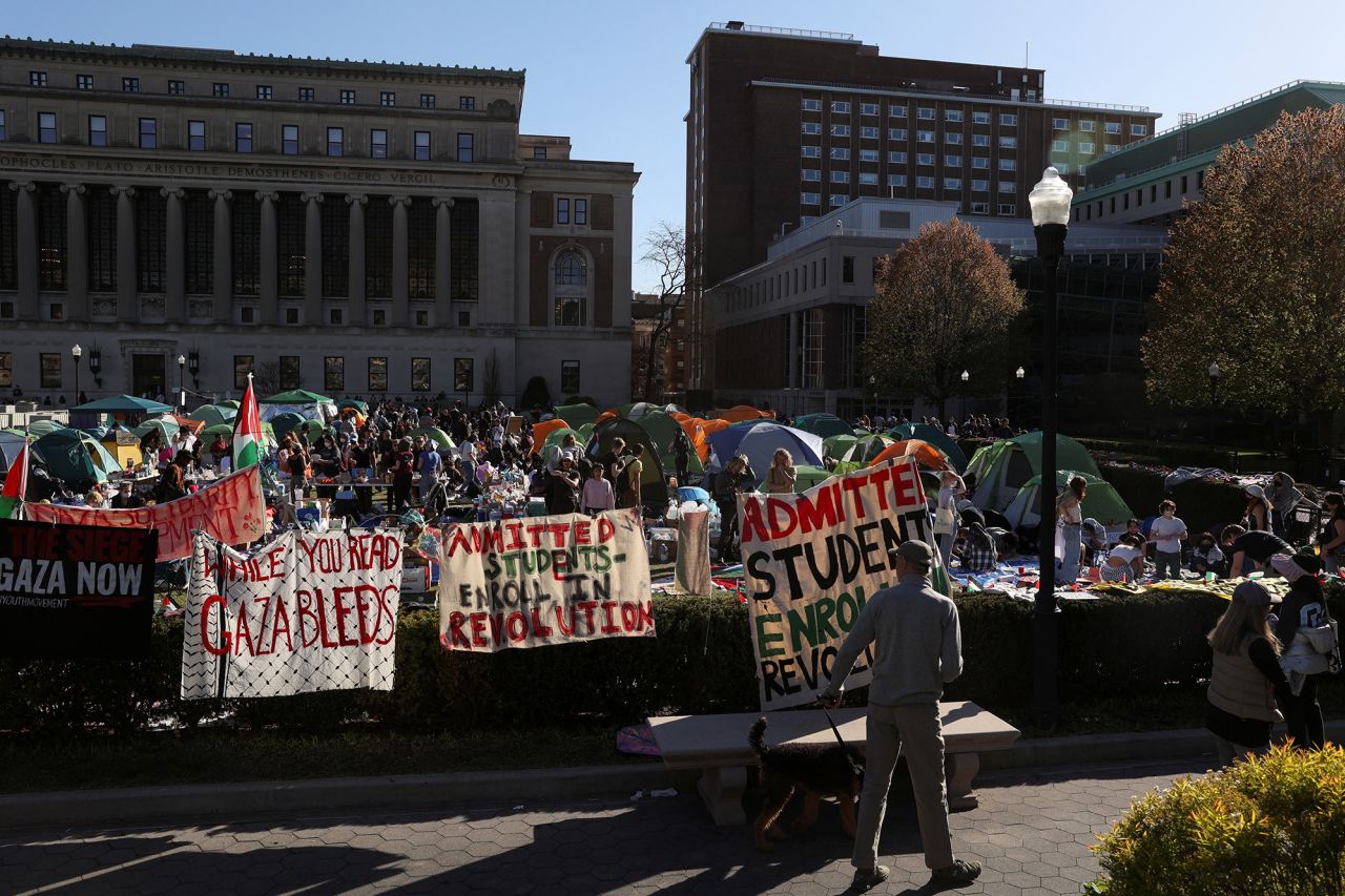 A man walking his dog stops to look at the area where students continue to hold a protest in support of Palestinians at Columbia University, during the ongoing conflict between Israel and the Palestinian Islamist group Hamas, in New York City, on April 22.