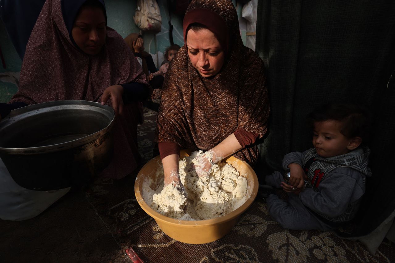 Displaced Palestinian women prepare bread inside a tent in Rafah, Gaza, on December 27. 