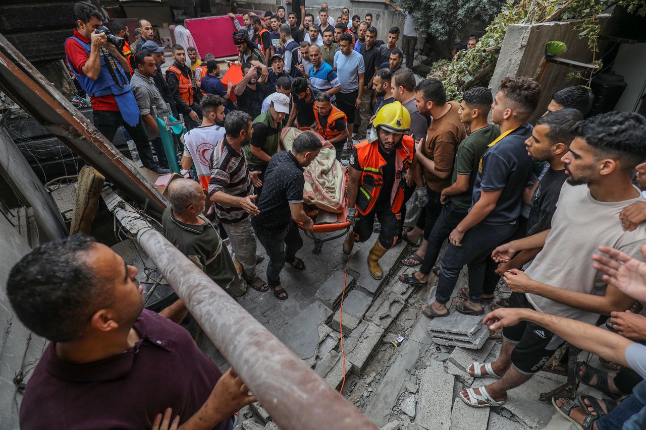 Rescuers carry the bodies of people pulled from collapsed buildings after Israeli airstrikes in Rafah, Gaza, on October 9.