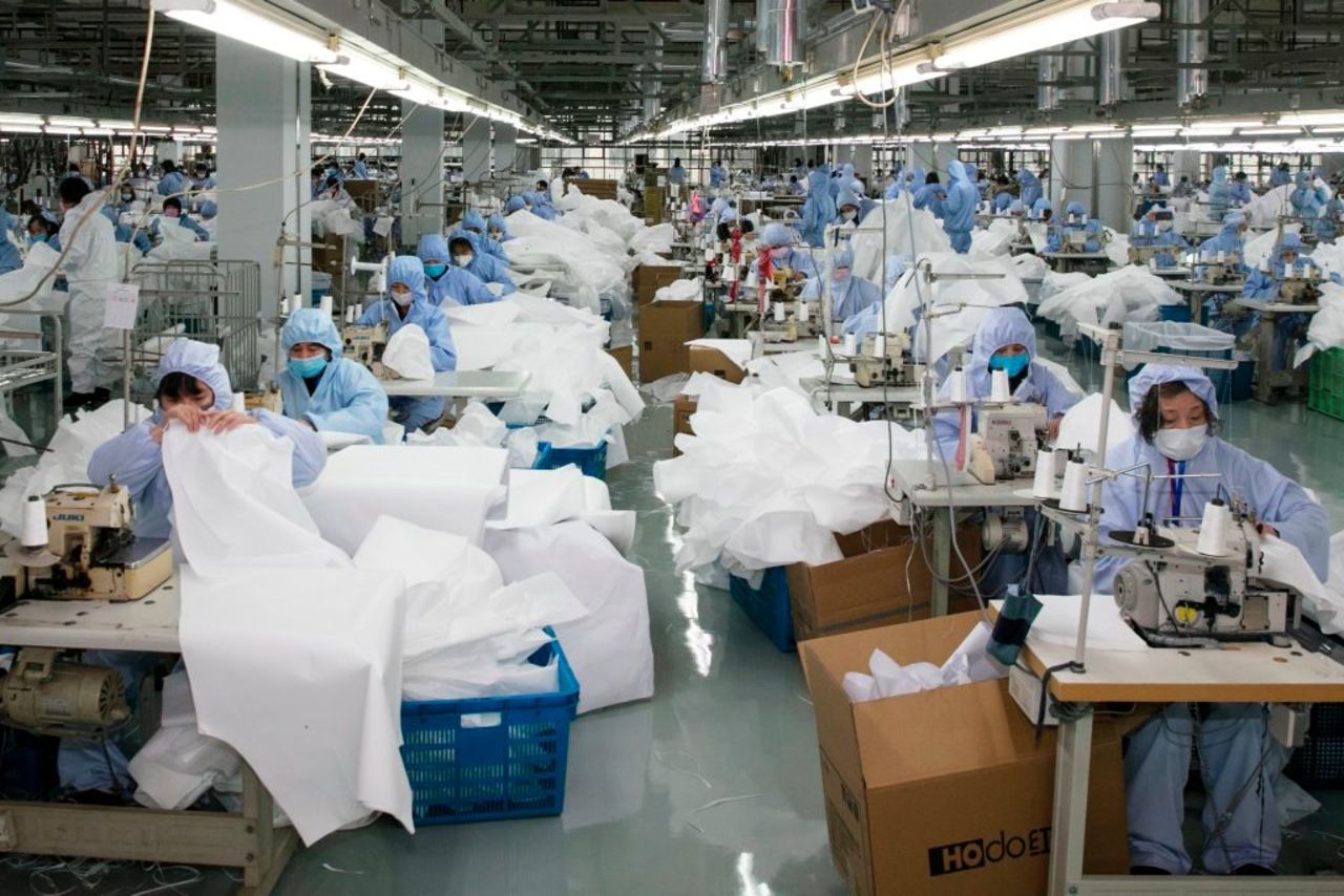 Workers producing protective clothing at a factory in Wuxi, in China's eastern Jiangsu province on February 8, 2020. 