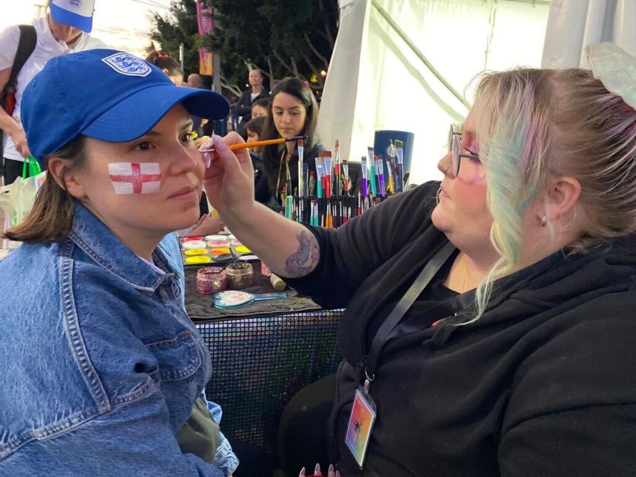 Adrienne Smith has her face painted by Kayla Appino before the Women's World Cup final.