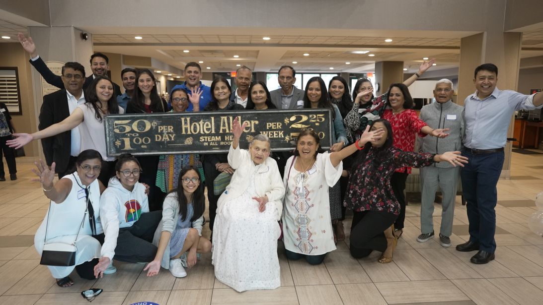Descendants of the original Patel hoteliers gather at a book signing for Doshi. They shout out 