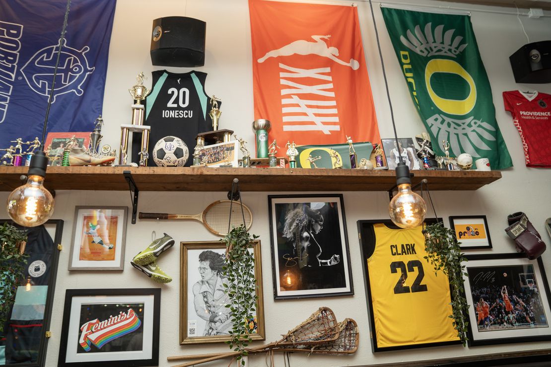 The trophy wall at The Sports Bra features memorabilia, signed jerseys and posters, game balls, trophies and more celebrating women athletes.