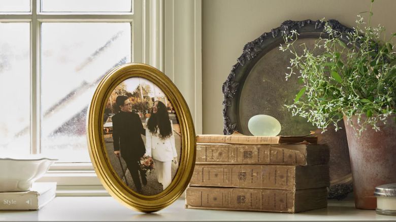 Framebridge Antiqued Oval Tabletop Frame near window and plants.
