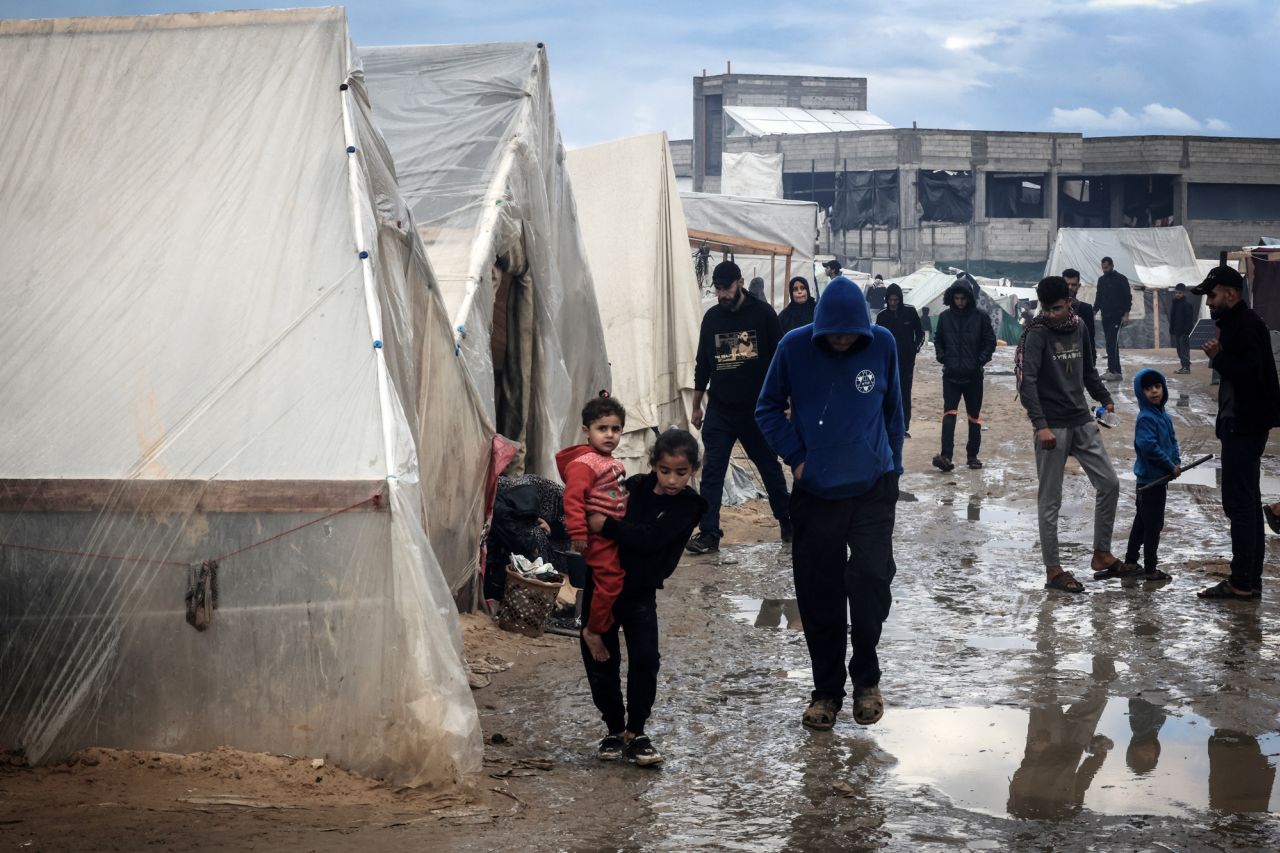 Palestinians walk past tents at a makeshift camp housing displaced Palestinians in Rafah, Gaza, on January 2.