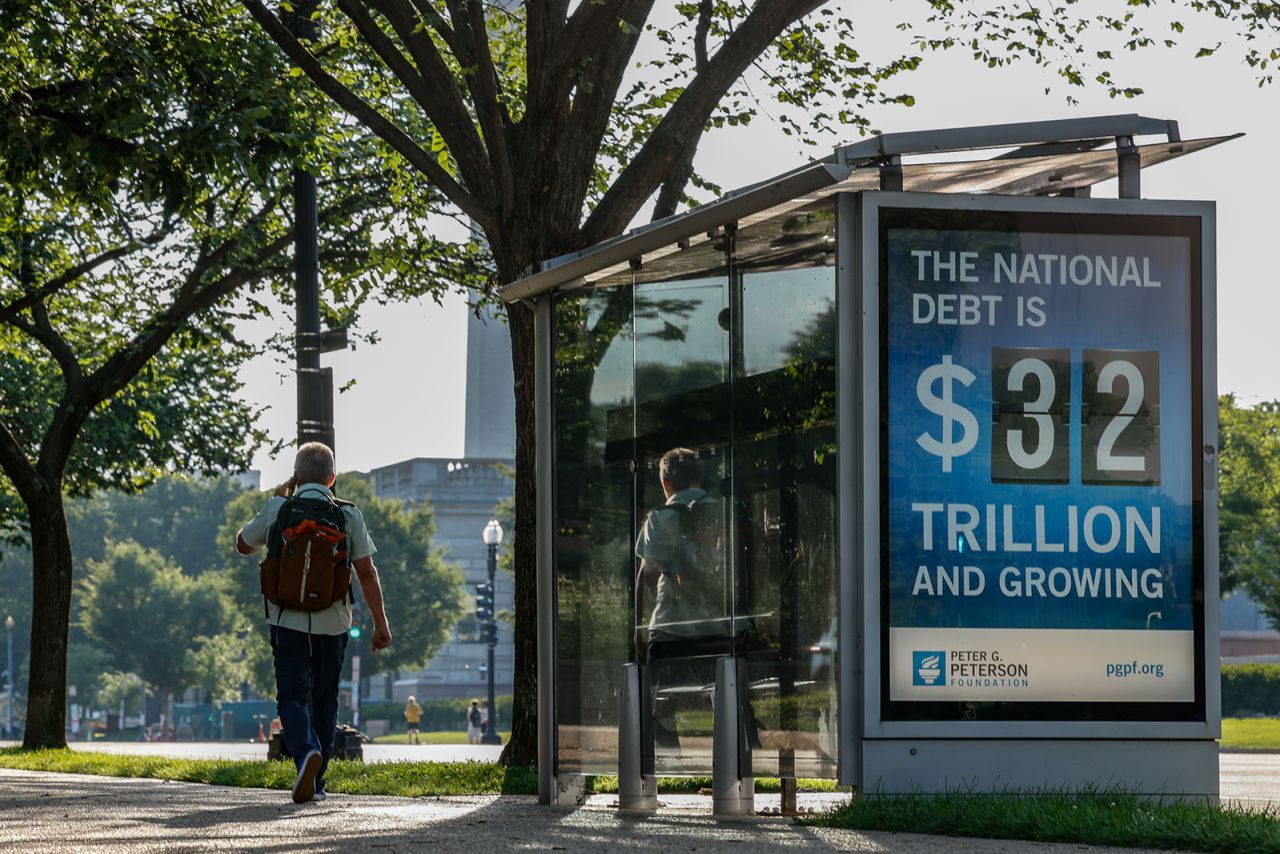 A pedestrian walks past an electronic billboard displaying the current U.S. national debt on July 6 in Washington, DC. 