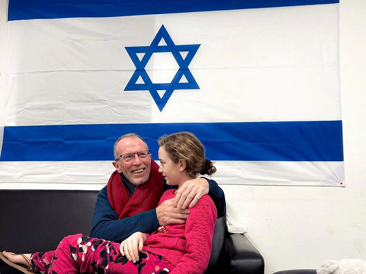 Emily Hand, who was abducted by Hamas gunmen during the October 7 attack on Israel, meets her father Thomas Hand after being released as part of a hostages-prisoners swap deal between Hamas and Israel amid a temporary truce on November 26, 