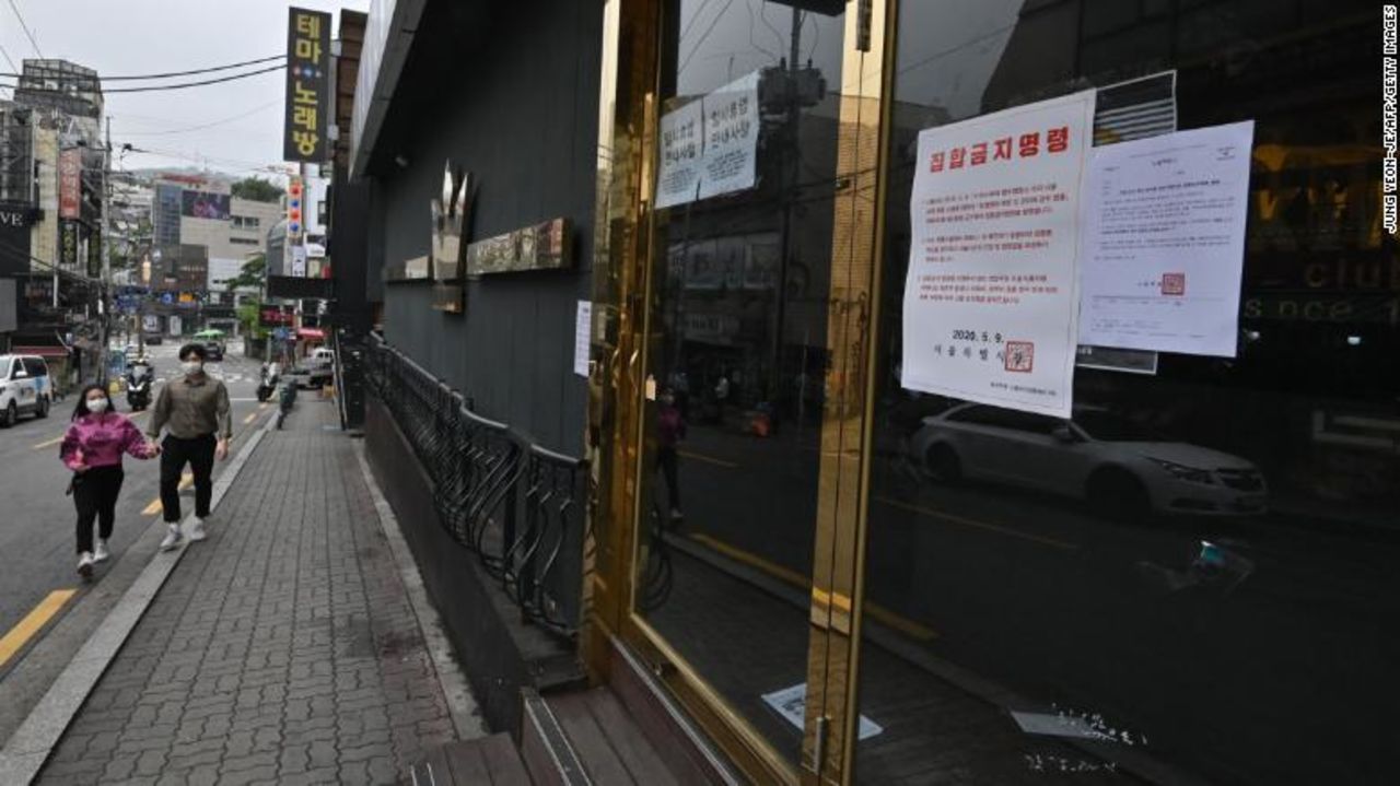 A couple wearing face masks walk past a closed nightclub in the popular nightlife district of Itaewon in Seoul on May 10.