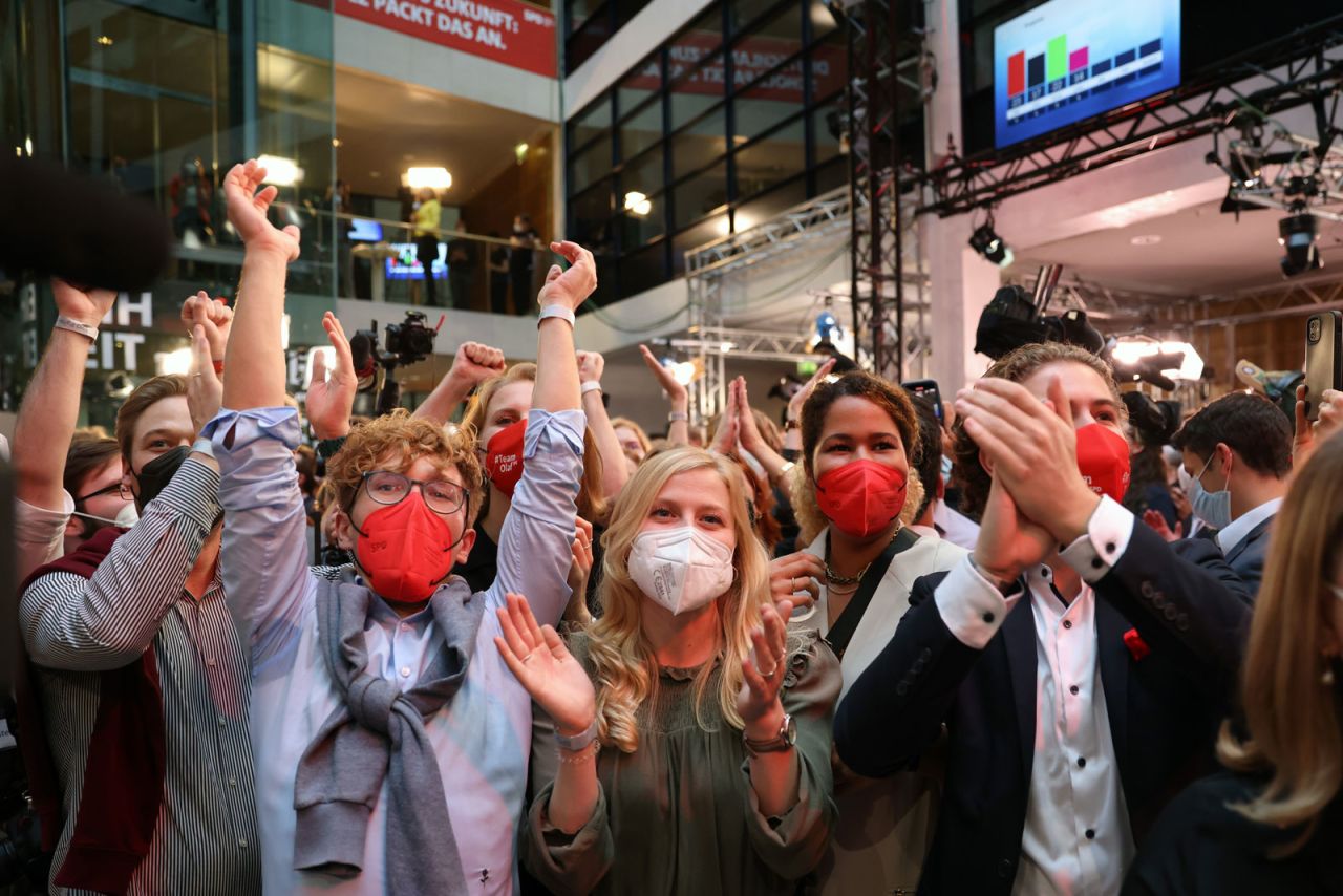 SPD members react to initial election results at their Berlin headquarters.