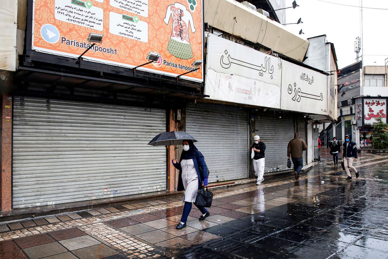 Pedestrians walk past closed shops along a street in Iran's capital Tehran on Nov. 21.