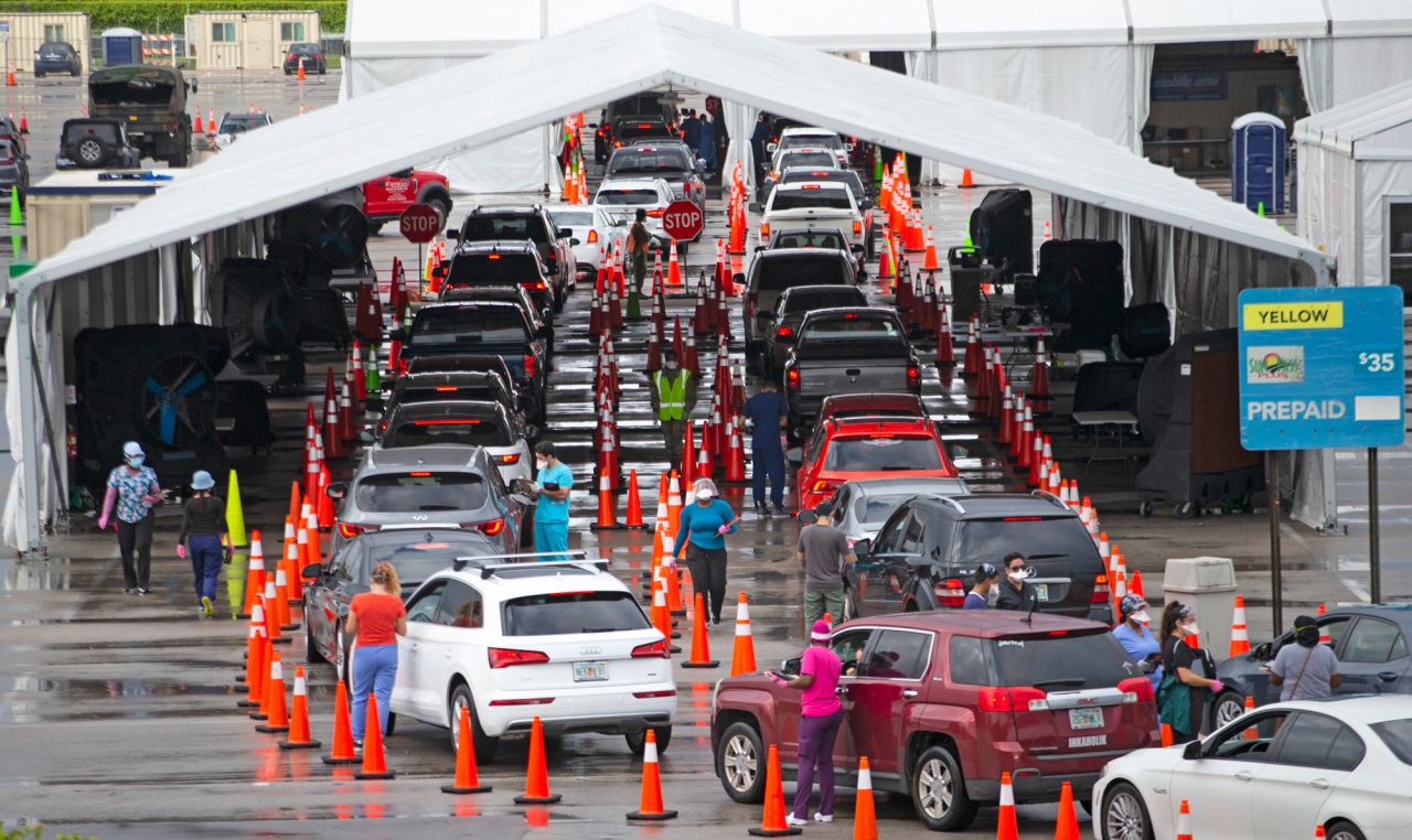 Vehicles line up as healthcare workers help to check-in people being tested at the COVID-19 drive-thru testing center at Hard Rock Stadium in Miami Gardens, Florida, on November 22.