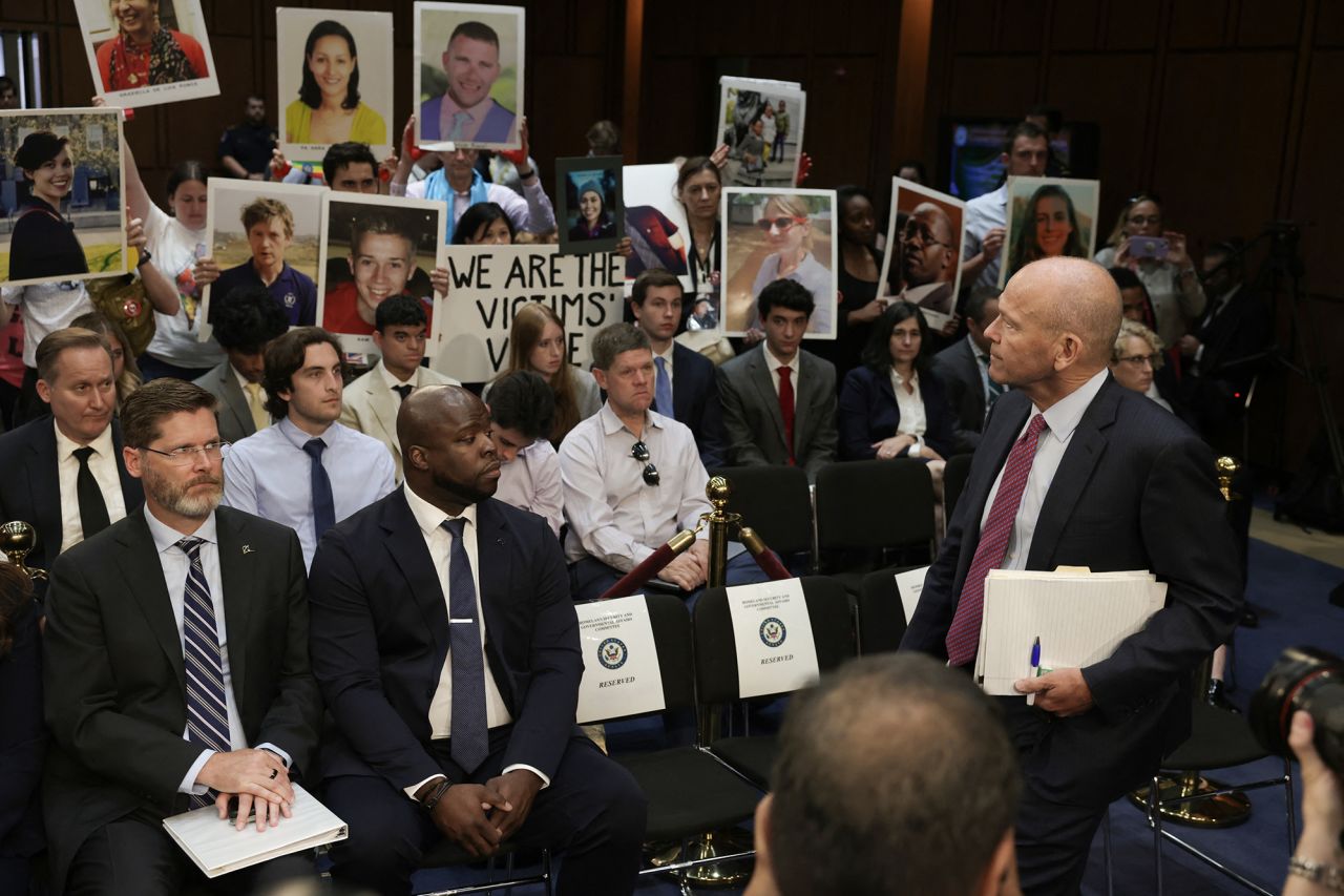 Relatives of Boeing airplane crash victims demonstrate as Boeing President and CEO Dave Calhoun (R) arrives to testify during a Senate Homeland Security and Governmental Affairs Committee Investigations Subcommittee hearing to examine "Boeing's broken safety culture" on Capitol Hill in Washington, DC, today.